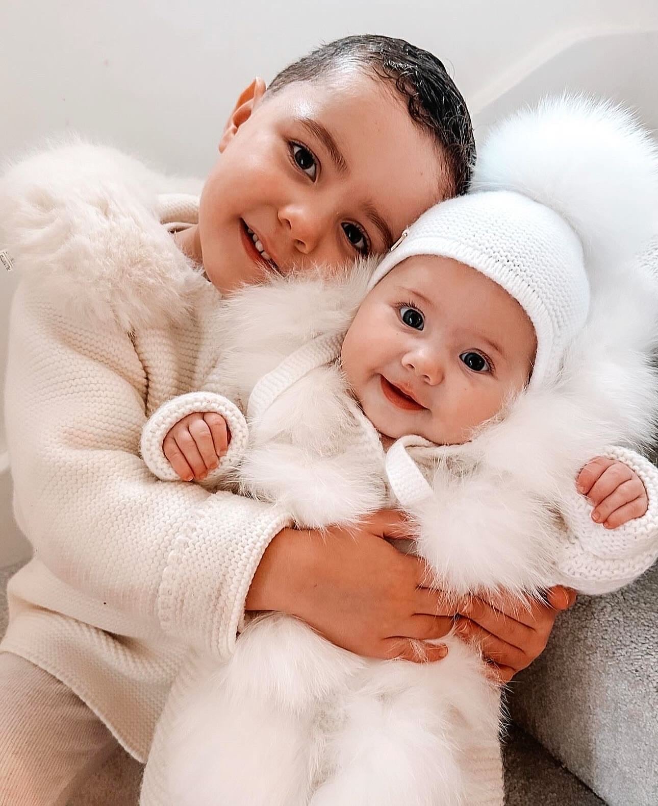 MI LOVES SIGNATURE Cream Knitted Pramsuit with Luxurious Fox fur trim.