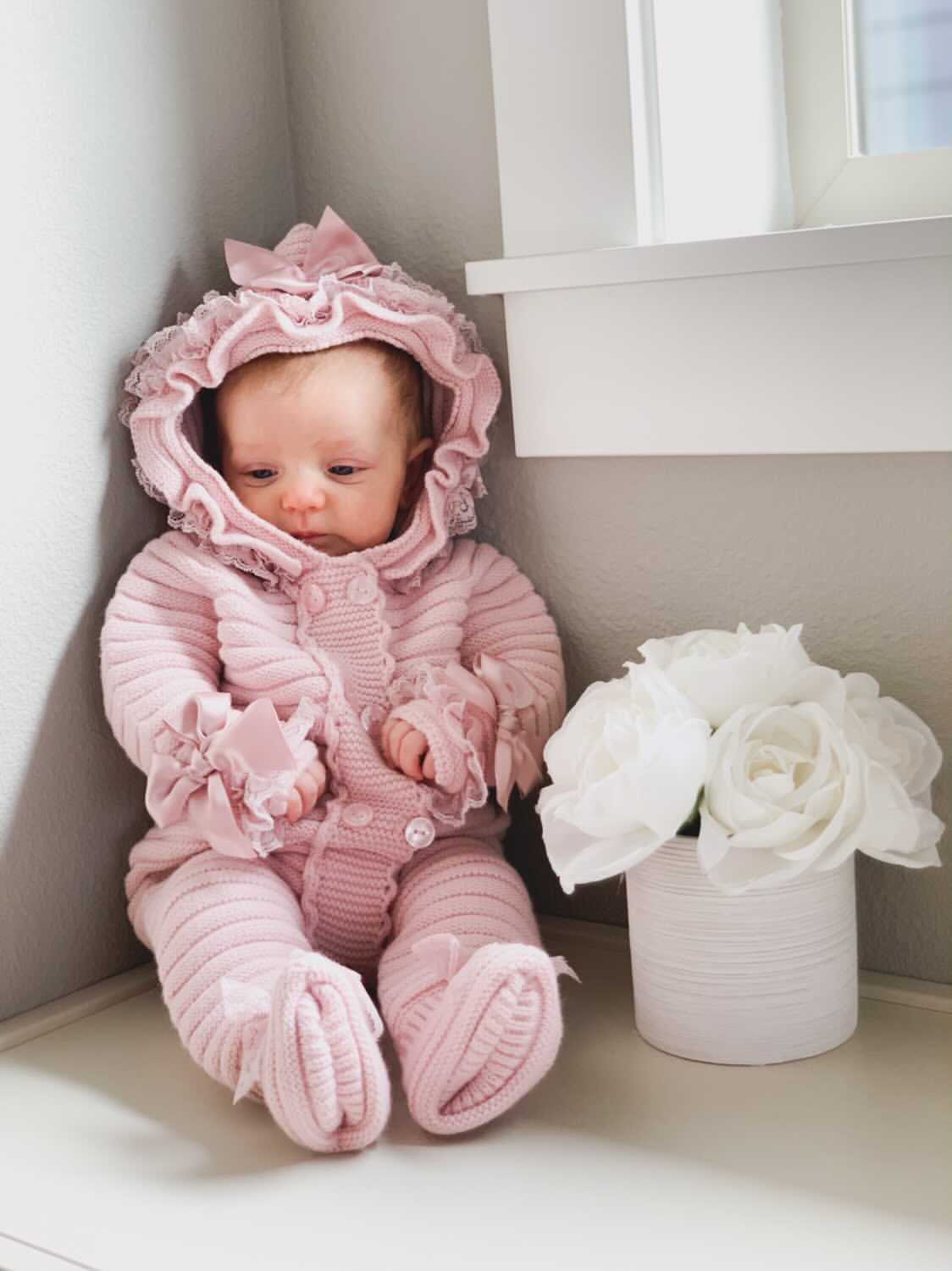 Knitted pram suit with bow and sold lace detail